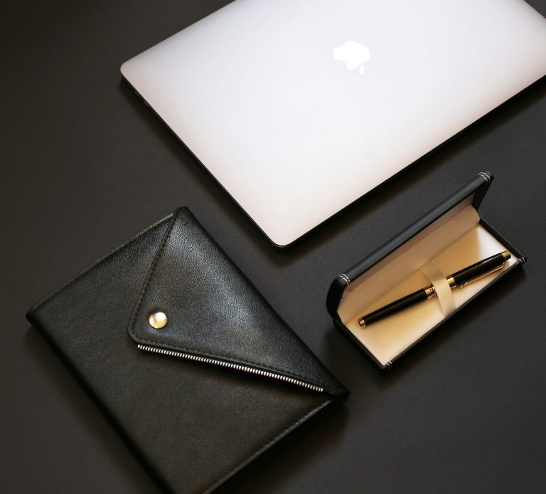 Ordinateur portable, porte-documents noir et étui avec un stylo.